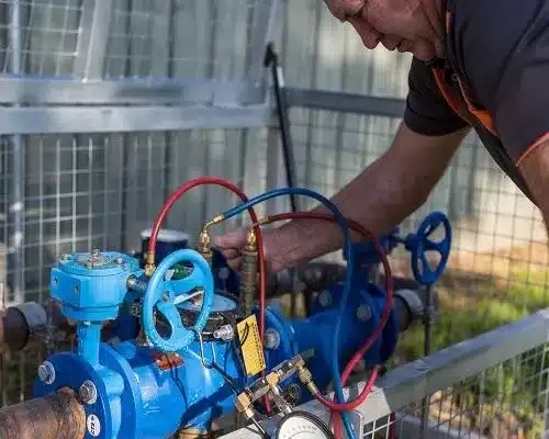 A technician working on a backflow prevention system