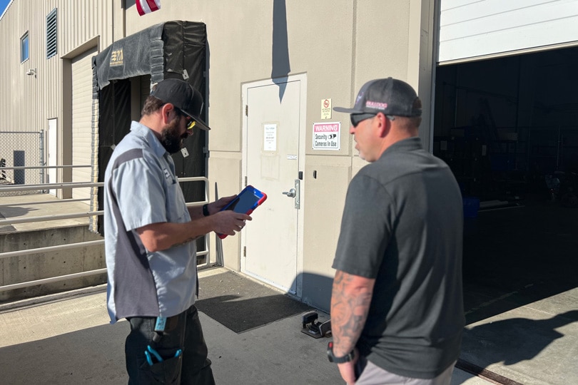 Two Bulldog Rooter technicians discussing a job