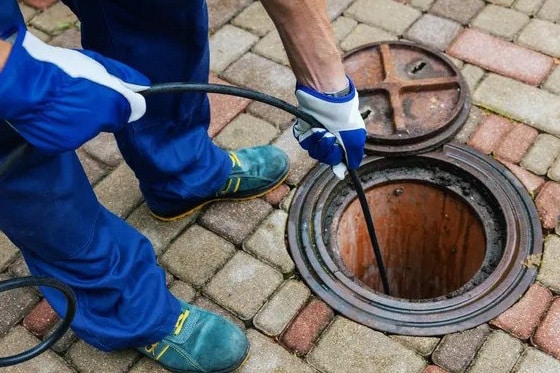 A person working on a drain