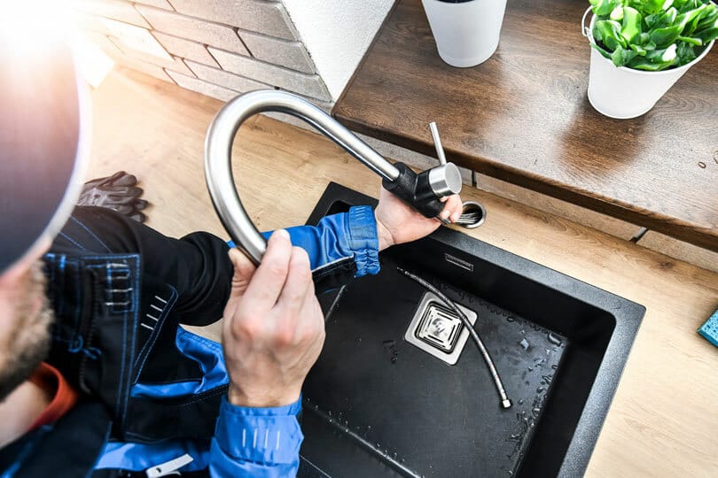 A technician working on a sink