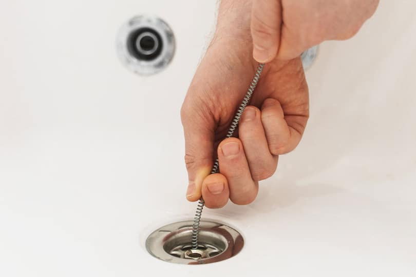 A technician working on clearing a drain