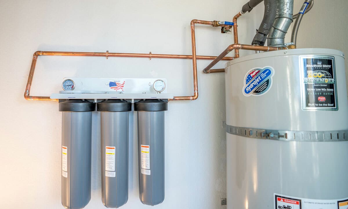 A water conditioning system next to the water heater in a home