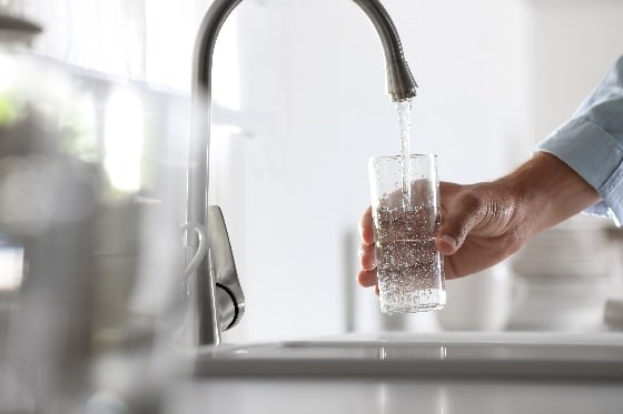 A photo of someone getting clean water out of their kitchen faucet