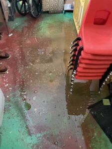 Sewer backup flooding floor inside Sprague building before mainline drain cleaning