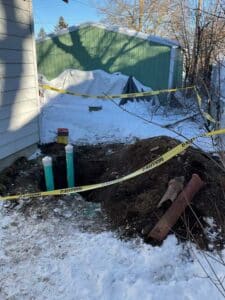 Excavated drain line area secured with caution tape during pipe installation in Spokane