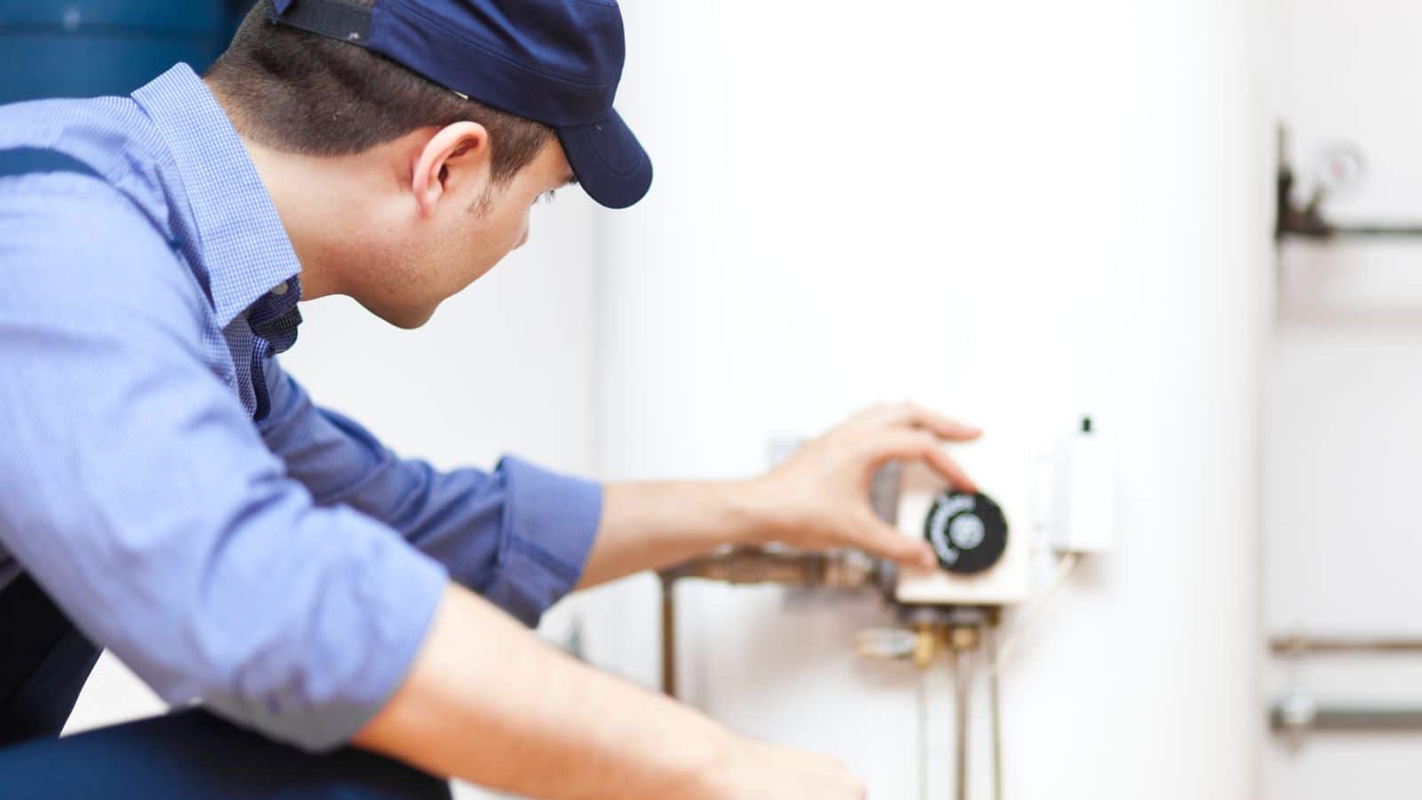 A plumber checking the temperature on a water heater