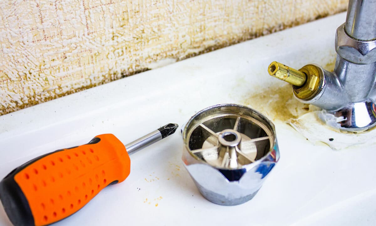 A sink faucet taken apart with tools