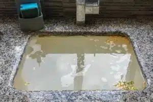 A sink full of dirty water due to a clogged up drain