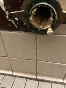 The urinal flange exposed showing clogged sludge